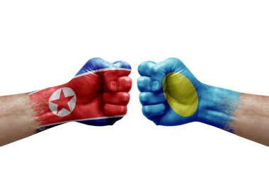 Two hands punch to each others on white background. Country flags painted fists, conflict crisis concept between north korea and palau