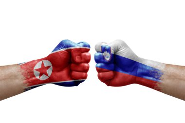 Two hands punch to each others on white background. Country flags painted fists, conflict crisis concept between north korea and slovenia