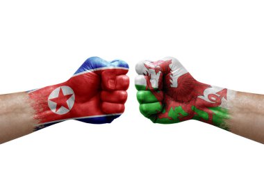 Two hands punch to each others on white background. Country flags painted fists, conflict crisis concept between north korea and wales