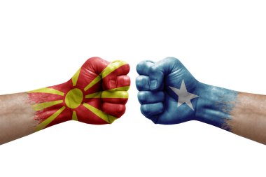 Two hands punch to each others on white background. Country flags painted fists, conflict crisis concept between north macedonia and somalia