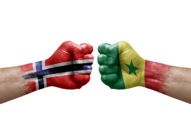 Two hands punch to each others on white background. Country flags painted fists, conflict crisis concept between norway and senegal