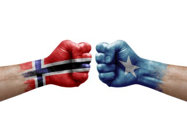 Two hands punch to each others on white background. Country flags painted fists, conflict crisis concept between norway and somalia