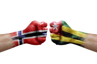Two hands punch to each others on white background. Country flags painted fists, conflict crisis concept between norway and togo