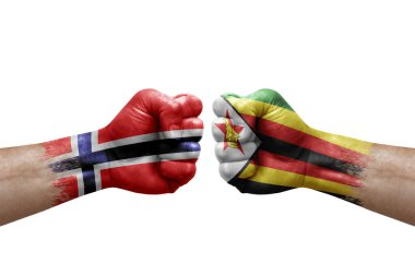 Two hands punch to each others on white background. Country flags painted fists, conflict crisis concept between norway and zimbabwe
