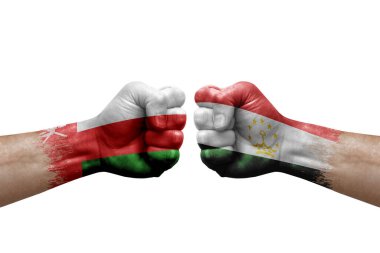 Two hands punch to each others on white background. Country flags painted fists, conflict crisis concept between oman and tajikistan