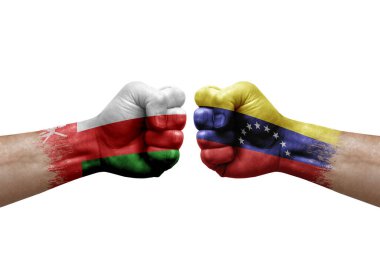 Two hands punch to each others on white background. Country flags painted fists, conflict crisis concept between oman and venezuela
