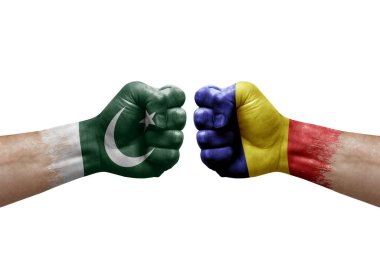 Two hands punch to each others on white background. Country flags painted fists, conflict crisis concept between pakistan and romania