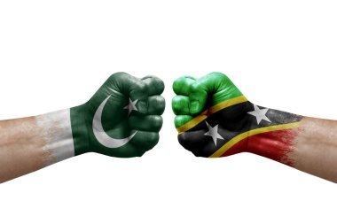 Two hands punch to each others on white background. Country flags painted fists, conflict crisis concept between pakistan and saint kitts and nevis