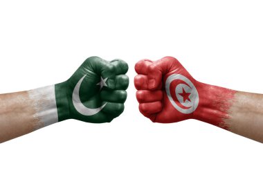 Two hands punch to each others on white background. Country flags painted fists, conflict crisis concept between pakistan and tunisia