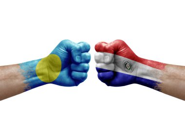 Two hands punch to each others on white background. Country flags painted fists, conflict crisis concept between palau and paraguay