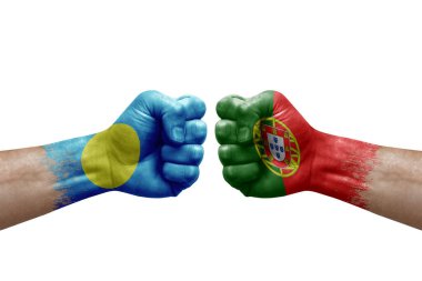 Two hands punch to each others on white background. Country flags painted fists, conflict crisis concept between palau and portugal