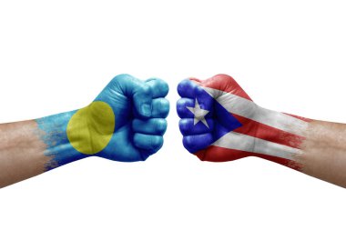Two hands punch to each others on white background. Country flags painted fists, conflict crisis concept between palau and puerto rico