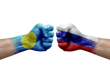Two hands punch to each others on white background. Country flags painted fists, conflict crisis concept between palau and russia