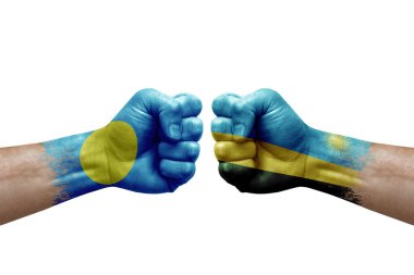 Two hands punch to each others on white background. Country flags painted fists, conflict crisis concept between palau and rwanda