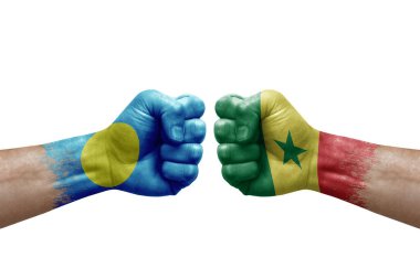 Two hands punch to each others on white background. Country flags painted fists, conflict crisis concept between palau and senegal