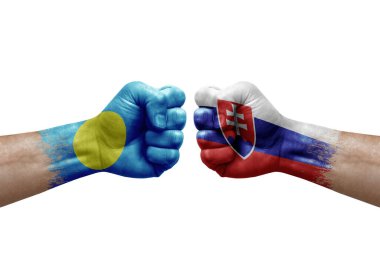Two hands punch to each others on white background. Country flags painted fists, conflict crisis concept between palau and slovakia