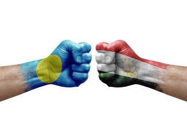 Two hands punch to each others on white background. Country flags painted fists, conflict crisis concept between palau and tajikistan