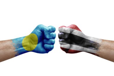 Two hands punch to each others on white background. Country flags painted fists, conflict crisis concept between palau and thailand