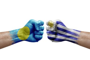Two hands punch to each others on white background. Country flags painted fists, conflict crisis concept between palau and uruguay