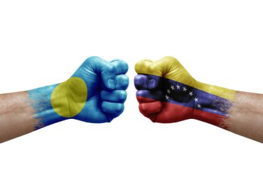 Two hands punch to each others on white background. Country flags painted fists, conflict crisis concept between palau and venezuela
