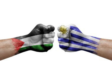 Two hands punch to each others on white background. Country flags painted fists, conflict crisis concept between palestine and uruguay
