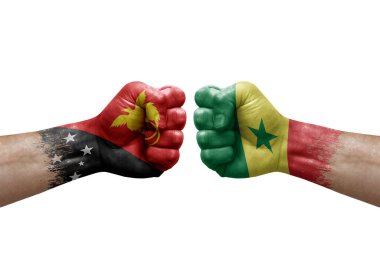 Two hands punch to each others on white background. Country flags painted fists, conflict crisis concept between papua new guinea and senegal