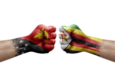 Two hands punch to each others on white background. Country flags painted fists, conflict crisis concept between papua new guinea and zimbabwe