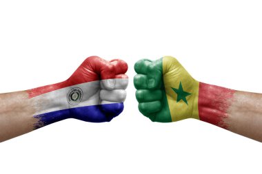 Two hands punch to each others on white background. Country flags painted fists, conflict crisis concept between paraguay and senegal