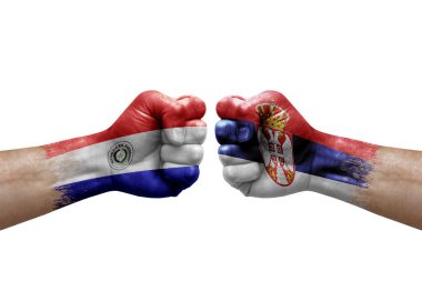 Two hands punch to each others on white background. Country flags painted fists, conflict crisis concept between paraguay and serbia