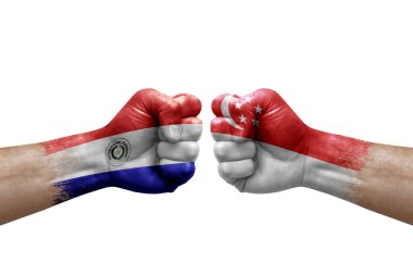 Two hands punch to each others on white background. Country flags painted fists, conflict crisis concept between paraguay and singapore