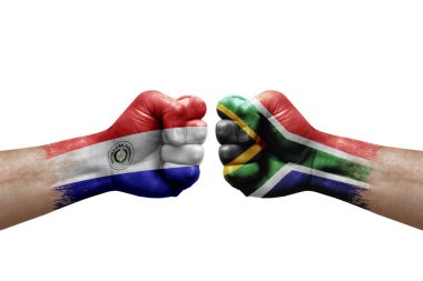 Two hands punch to each others on white background. Country flags painted fists, conflict crisis concept between paraguay and south africa