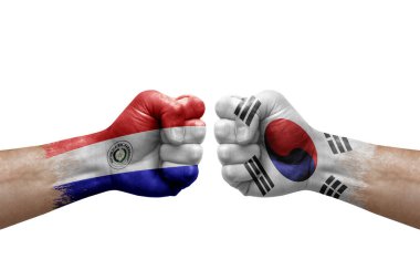 Two hands punch to each others on white background. Country flags painted fists, conflict crisis concept between paraguay and south korea