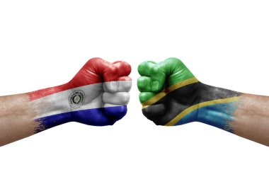 Two hands punch to each others on white background. Country flags painted fists, conflict crisis concept between paraguay and tanzania