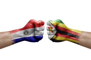 Two hands punch to each others on white background. Country flags painted fists, conflict crisis concept between paraguay and zimbabwe