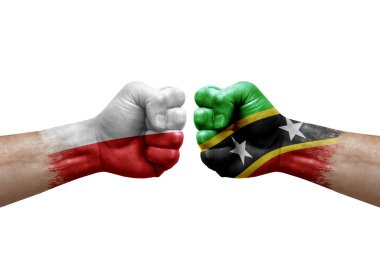 Two hands punch to each others on white background. Country flags painted fists, conflict crisis concept between poland and saint kitts and nevis