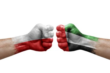 Two hands punch to each others on white background. Country flags painted fists, conflict crisis concept between poland and united arab emirates