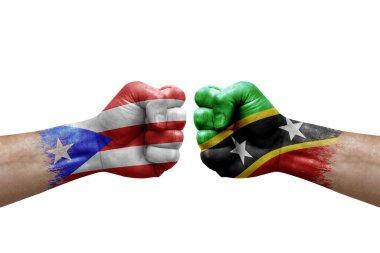 Two hands punch to each others on white background. Country flags painted fists, conflict crisis concept between puerto rico and saint kitts and nevis