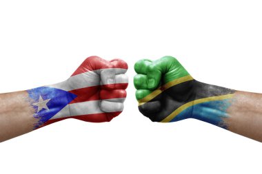 Two hands punch to each others on white background. Country flags painted fists, conflict crisis concept between puerto rico and tanzania