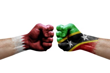Two hands punch to each others on white background. Country flags painted fists, conflict crisis concept between qatar and saint kitts and nevis
