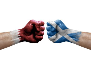 Two hands punch to each others on white background. Country flags painted fists, conflict crisis concept between qatar and scotland