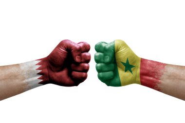 Two hands punch to each others on white background. Country flags painted fists, conflict crisis concept between qatar and senegal