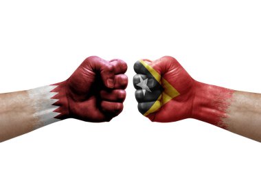 Two hands punch to each others on white background. Country flags painted fists, conflict crisis concept between qatar and timor leste