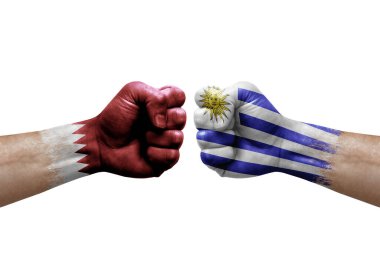 Two hands punch to each others on white background. Country flags painted fists, conflict crisis concept between qatar and uruguay