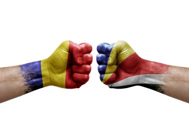 Two hands punch to each others on white background. Country flags painted fists, conflict crisis concept between romania and seychelles