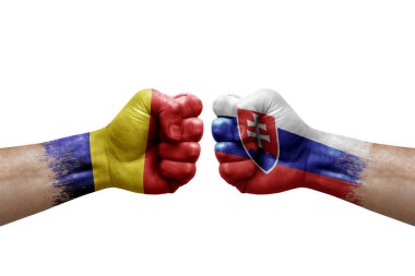 Two hands punch to each others on white background. Country flags painted fists, conflict crisis concept between romania and slovakia