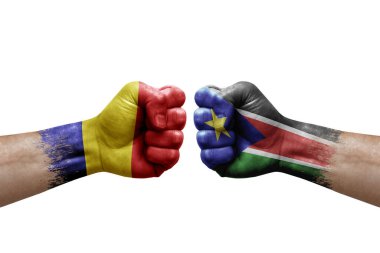 Two hands punch to each others on white background. Country flags painted fists, conflict crisis concept between romania and south sudan