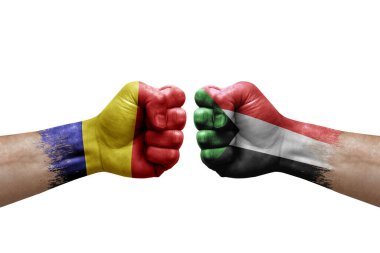 Two hands punch to each others on white background. Country flags painted fists, conflict crisis concept between romania and sudan