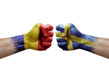 Two hands punch to each others on white background. Country flags painted fists, conflict crisis concept between romania and sweden
