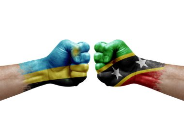 Two hands punch to each others on white background. Country flags painted fists, conflict crisis concept between rwanda and saint kitts and nevis