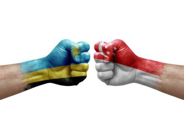 Two hands punch to each others on white background. Country flags painted fists, conflict crisis concept between rwanda and singapore